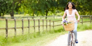 woman riding bicycle flower basket
